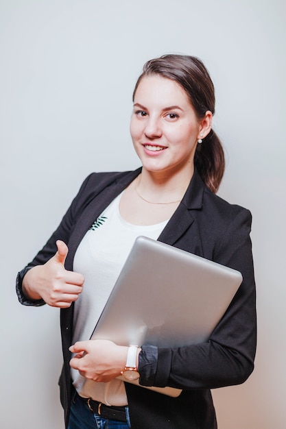 Woman with laptop gesturing thumb up