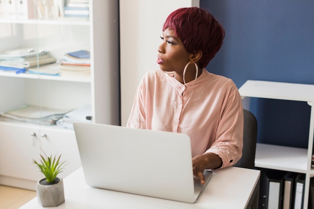 Woman with laptop looking away