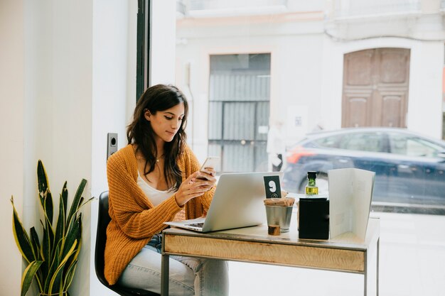 女性、ラップトップ、スマートフォン、カフェ