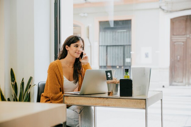 Woman with laptop speaking on phone