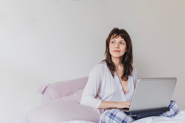 Woman with laptop thinking