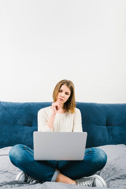 Woman with laptop thinking