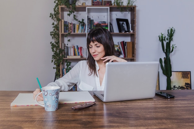 Woman with laptop writing