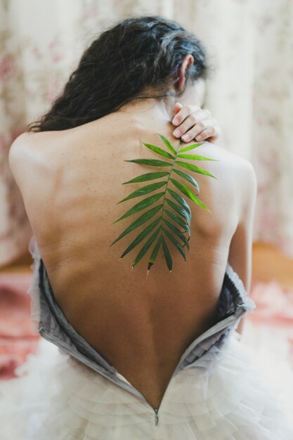 Woman with leaf on shoulder