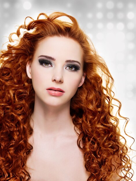 Woman with  long curly hairs and stylish purple make-up.  Blinking Background. Bokeh