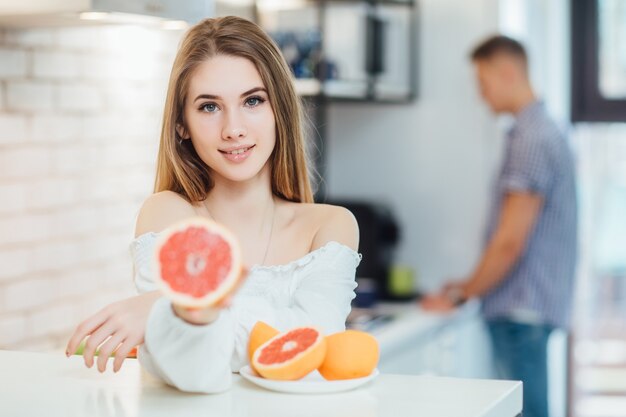 Woman with long hair girl colorful eyes makeup holding grapefruit citrus