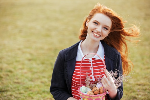 Free photo woman with long hair holding easter picnic basket