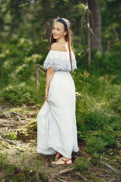 Woman with long hair. Lady in a blue dress. Girl with untouched nature.