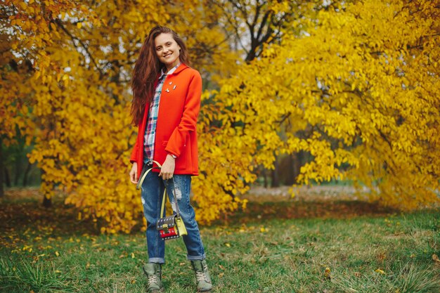 woman with long wavy hair enjoying autumn in the park.