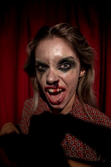 Woman with make-up blood on her face looking at camera