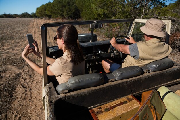 Woman with man photographing while traveling in vehicle