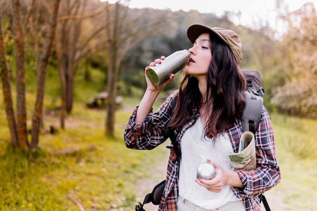 Woman with map drinking from thermos