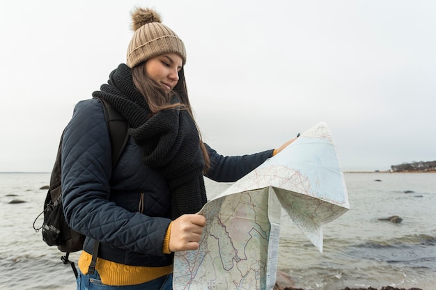 海の近くの地図を持つ女性