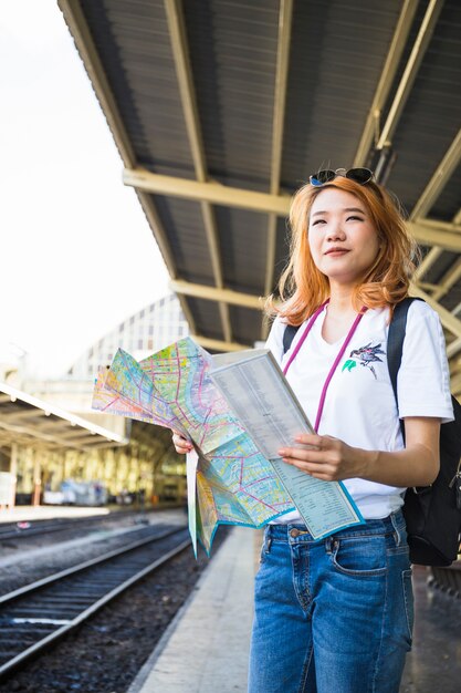 Donna con mappa sulla piattaforma