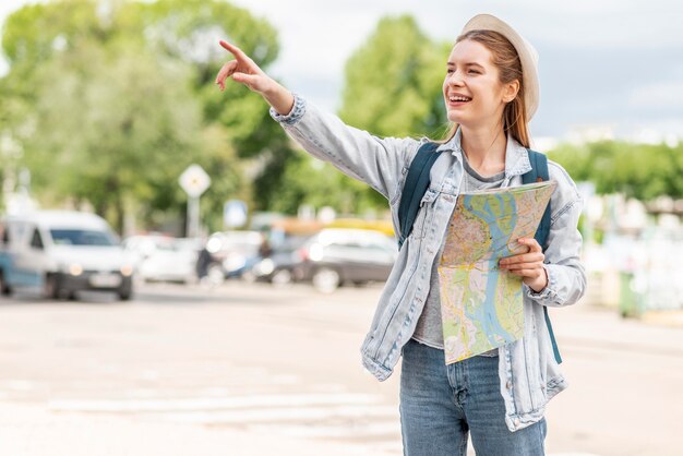 Woman with map pointing her finger in the air