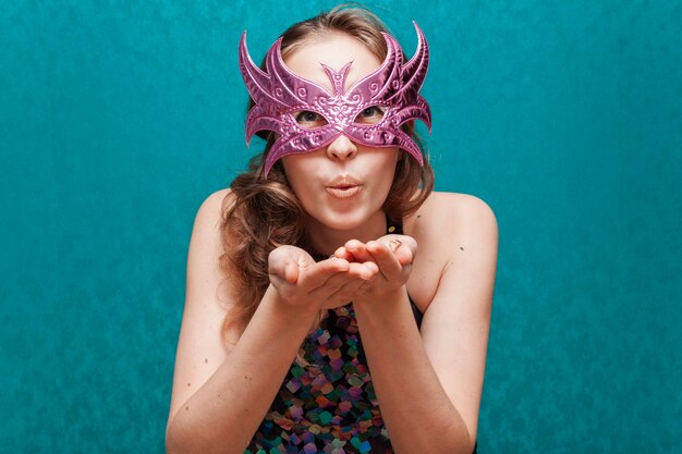 Woman with mask blowing a kiss