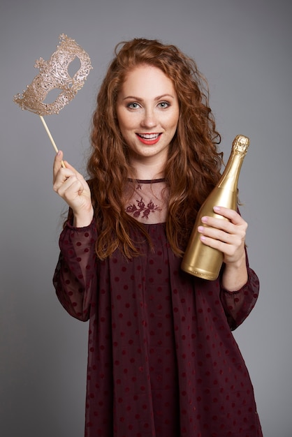 Woman with mask and champagne