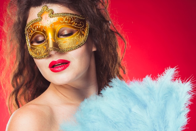 Woman with mask and feather fan