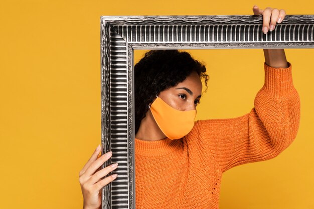 Woman with mask posing with frame