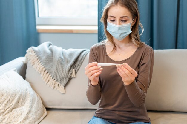 Woman with mask staying in quarantine on a couch