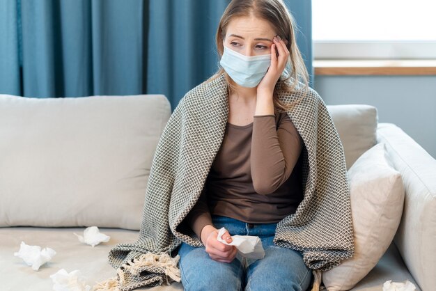Woman with mask staying in quarantine and having a fever