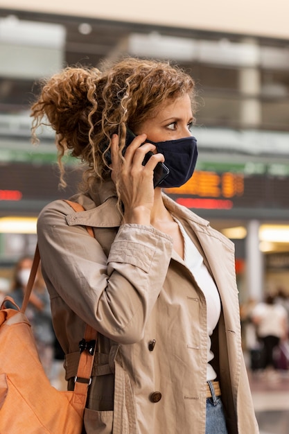 Free photo woman with mask talking on the phone