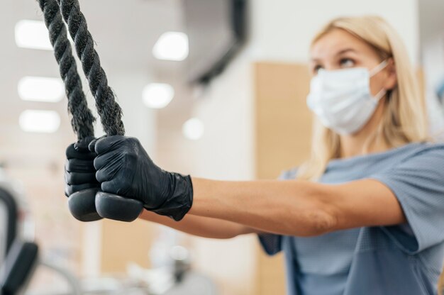 Woman with mask training at the gym during the pandemic