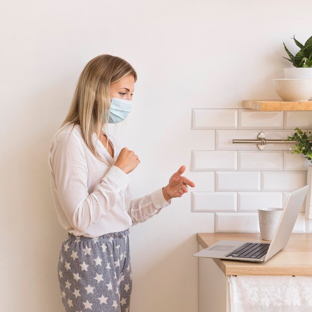 Woman with mask working from home