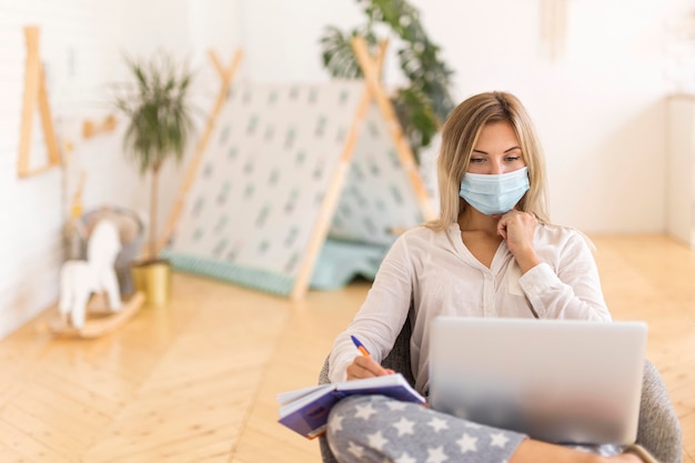 Woman with mask working at home
