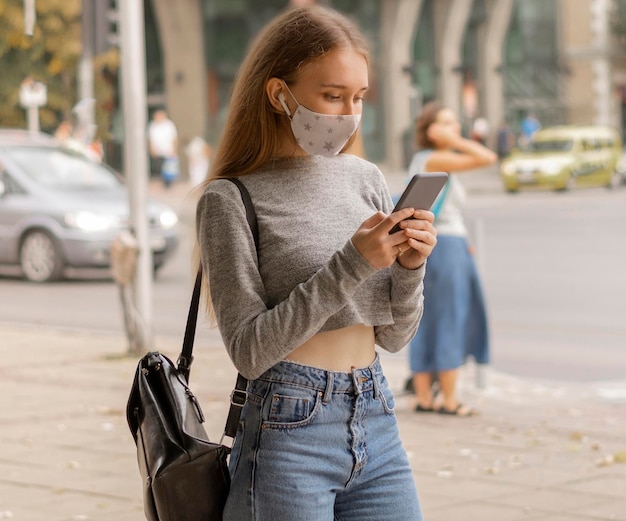Woman with medical mask checking her phone
