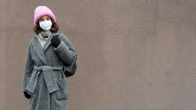 市内の医療マスクとコピースペースを持つ女性