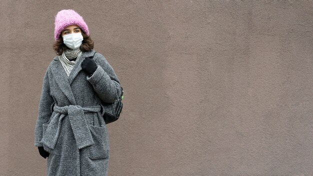 Woman with medical mask in the city and copy space