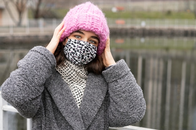 湖の隣の街で医療マスクを持つ女性