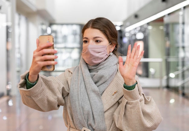 Woman with medical mask having a video call