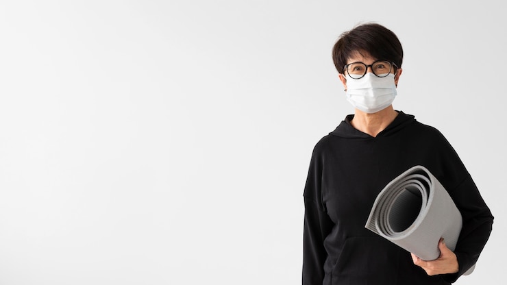 무료 Photo 피트 니스 매트를 들고 의료 마스크와 여자