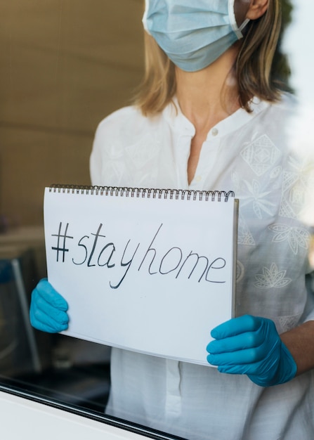 Free photo woman with medical mask holding stay home notebook