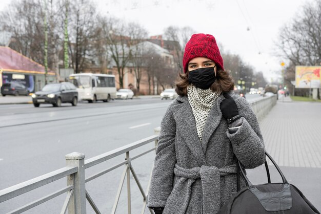 Woman with medical mask outdoors walking