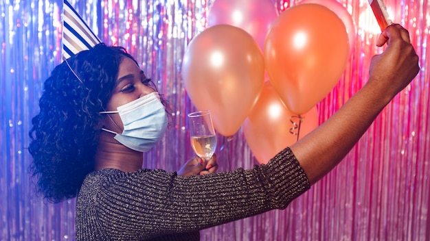 Donna con mascherina medica prendendo un selfie