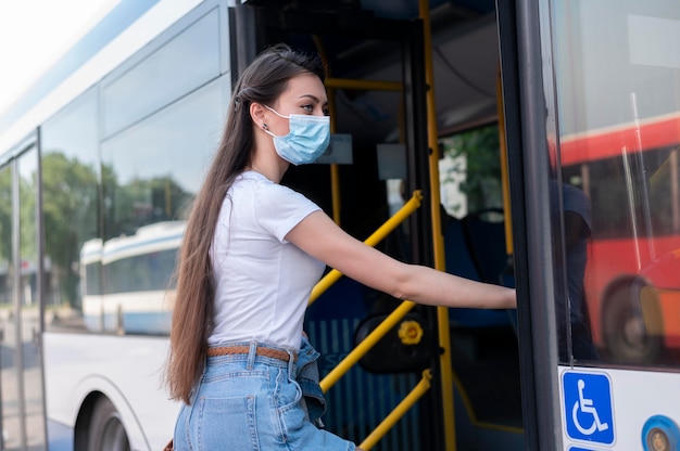 대중 교통 버스를 사용하여 의료 마스크를 쓴 여성
