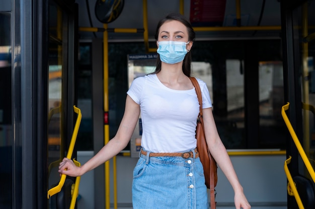 Woman with medical mask using public bus for transportation