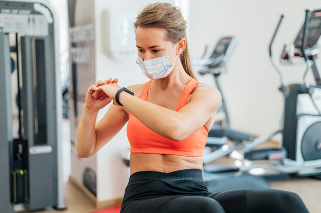 Woman with medical mask working out