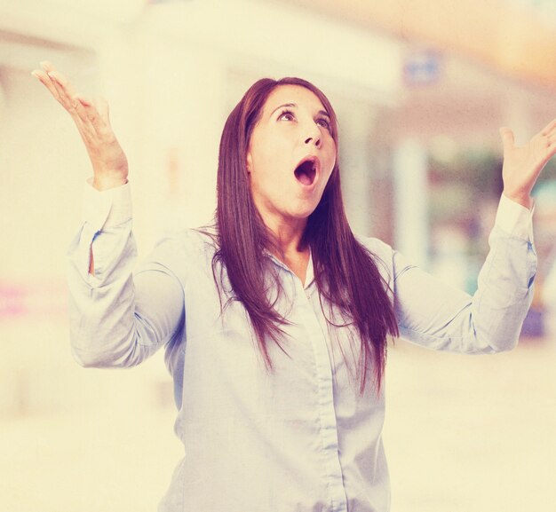 Woman with mouth open and hands raised