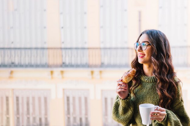 Free photo woman with mug and croissant