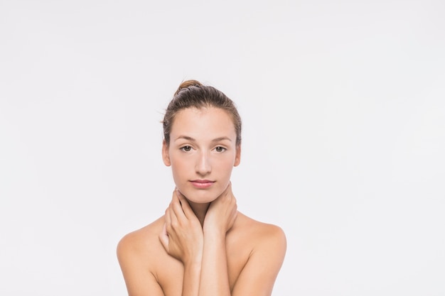 Woman with naked shoulders touching neck