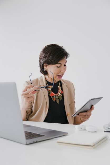 Free photo woman with necklace holding a tablet