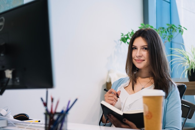 Woman with notebook and looking at camera