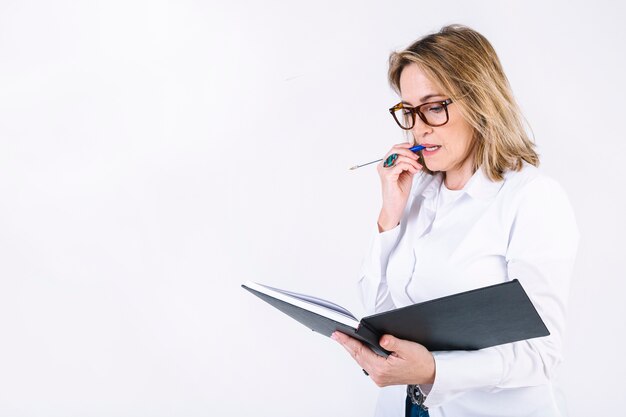 Woman with notebook thinking over problem