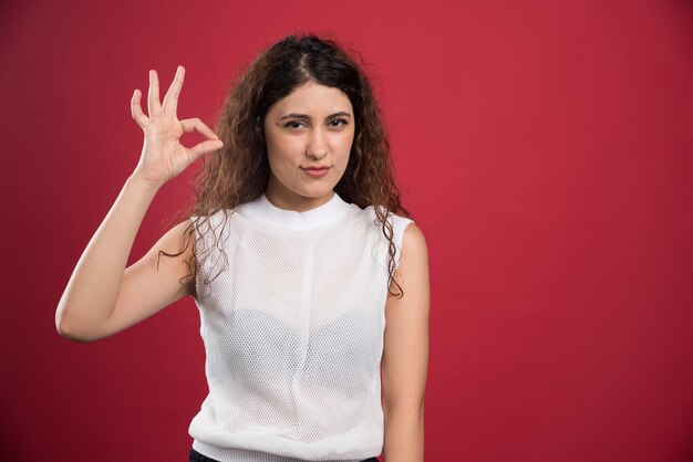 Woman with ok gesture on red