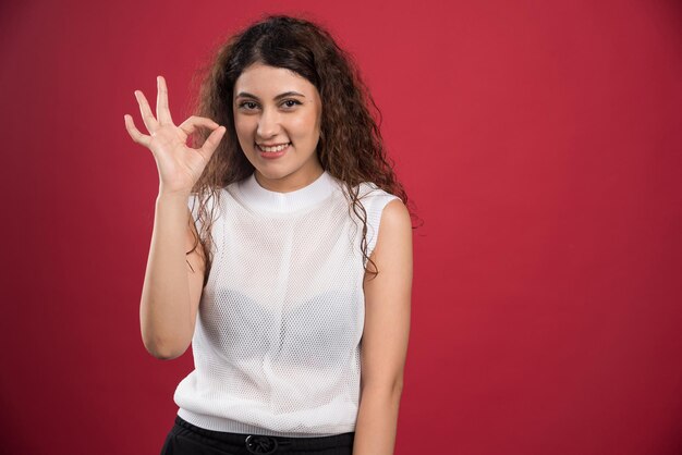 Woman with ok gesture on red