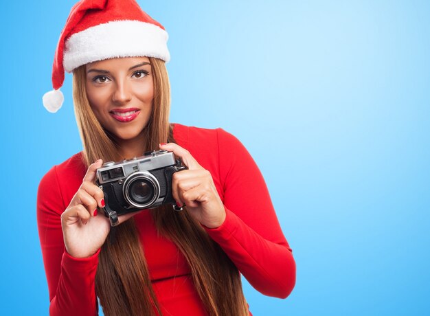 Woman with an old camera in a blue background